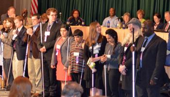 NFB Scholarship students lined up in front of the dais to introduce themselves to the NFB convention.
